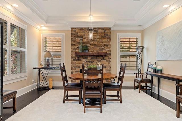 dining room featuring a raised ceiling, dark hardwood / wood-style floors, and crown molding