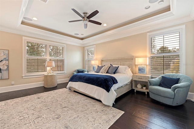 bedroom featuring ceiling fan, a tray ceiling, dark hardwood / wood-style floors, and crown molding