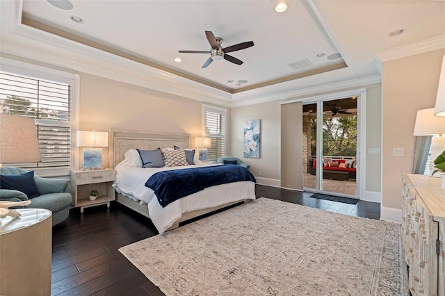 bedroom featuring dark hardwood / wood-style flooring, access to outside, ornamental molding, ceiling fan, and a tray ceiling