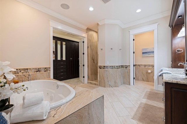 bathroom with tile walls, vanity, ornamental molding, and shower with separate bathtub