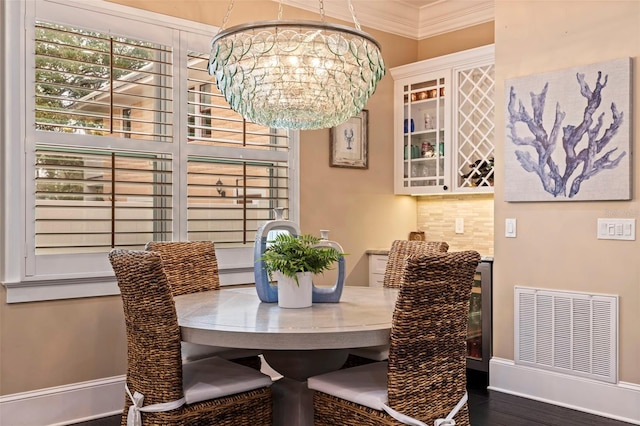 310 8th Ave N, Saint Petersburg, FL 33701 - dining room featuring crown molding, a chandelier, wood finished floors, and baseboards