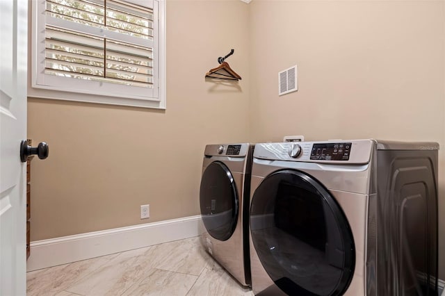 310 8th Ave N, Saint Petersburg, FL 33701 - washroom with washing machine and clothes dryer, baseboards, and marble look tile flooring