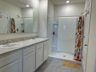 bathroom featuring curtained shower, vanity, and tile patterned flooring