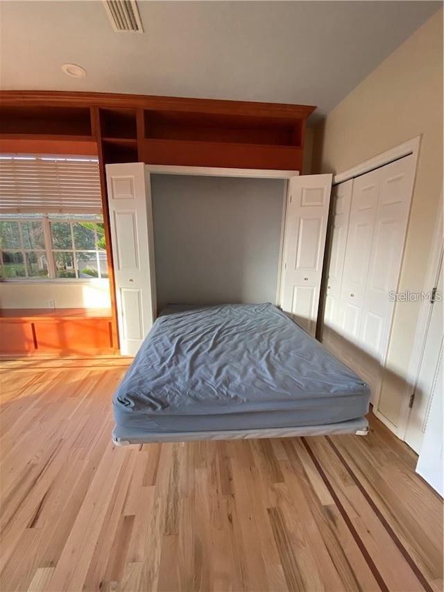 bedroom with wood-type flooring and a closet