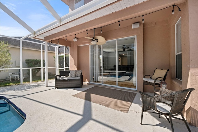 view of patio with ceiling fan, an outdoor hangout area, and glass enclosure