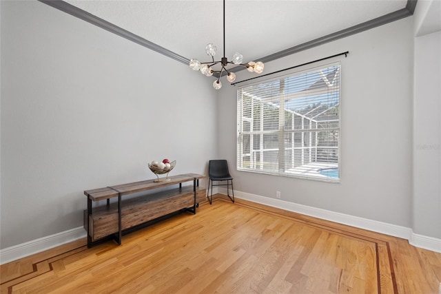 sitting room with a notable chandelier, hardwood / wood-style flooring, and ornamental molding