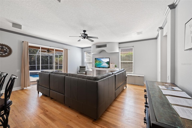 living room featuring crown molding, a textured ceiling, and light hardwood / wood-style flooring