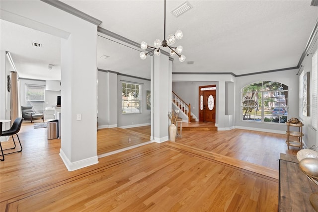 living room with hardwood / wood-style floors, ornamental molding, and a chandelier