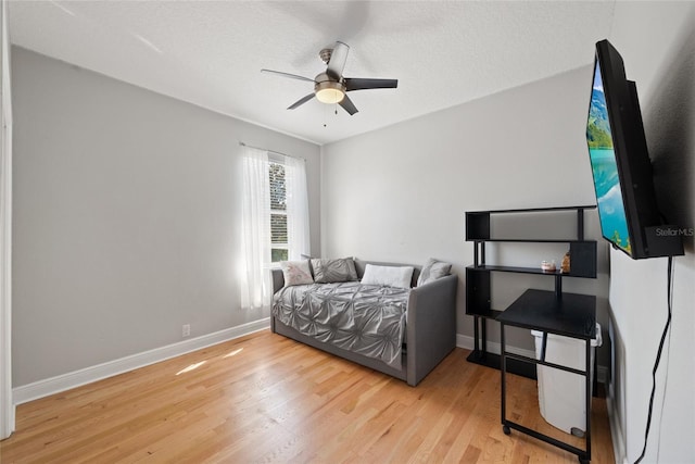 bedroom featuring a textured ceiling, light hardwood / wood-style flooring, and ceiling fan