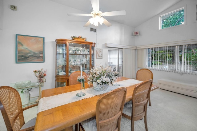 carpeted dining space featuring ceiling fan and vaulted ceiling