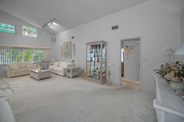 carpeted living room featuring high vaulted ceiling, rail lighting, and ceiling fan