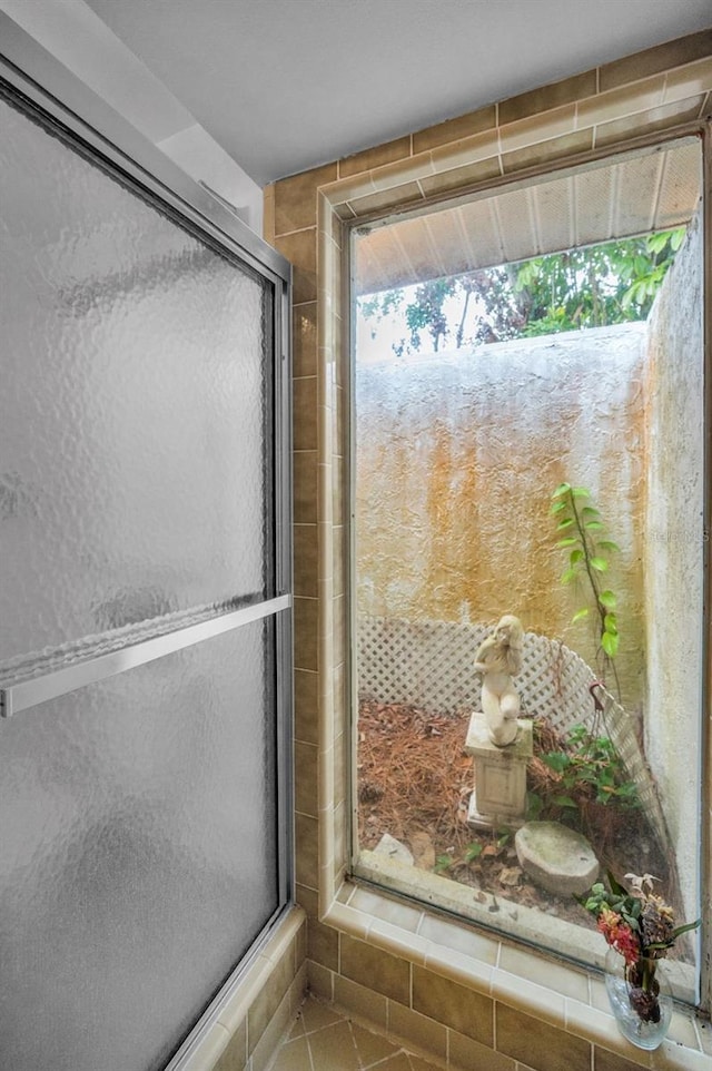 bathroom featuring tile patterned floors and a shower with shower door