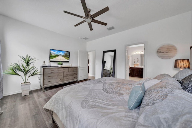 bedroom featuring ceiling fan, ensuite bath, and wood-type flooring