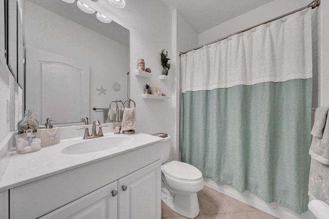 bathroom with toilet, vanity, tile patterned flooring, and a textured ceiling