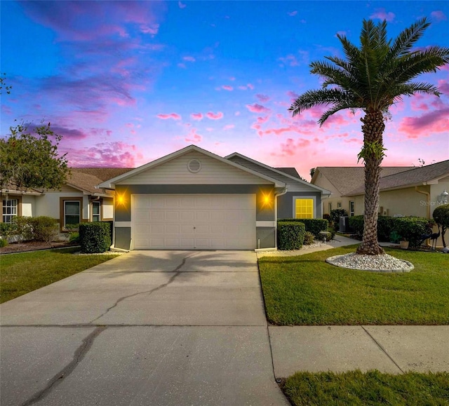 ranch-style home with a yard and a garage