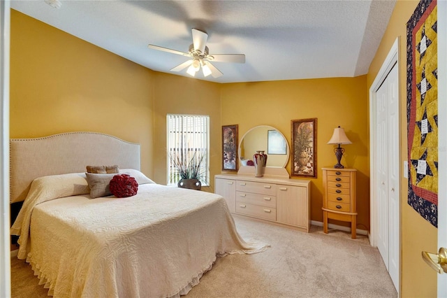 carpeted bedroom featuring a textured ceiling, a closet, and ceiling fan