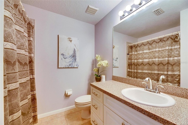 bathroom featuring a textured ceiling, tile patterned flooring, vanity, toilet, and walk in shower