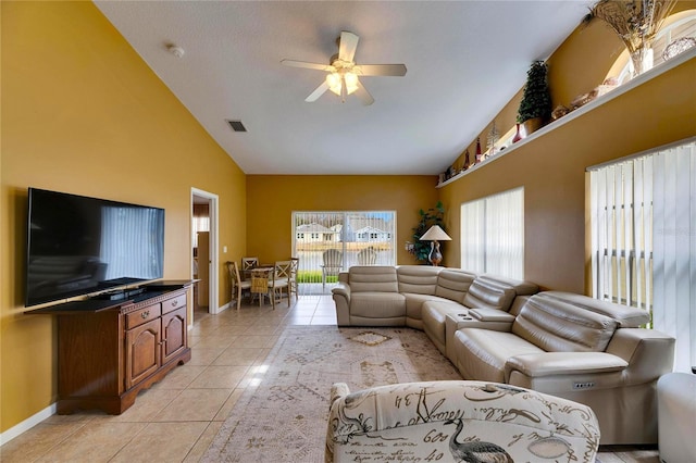 tiled living room with ceiling fan and vaulted ceiling