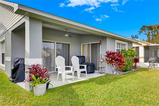 back of property with ceiling fan, a patio, and a yard