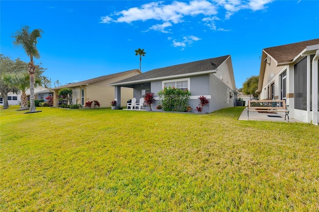 back of house with a lawn and a patio