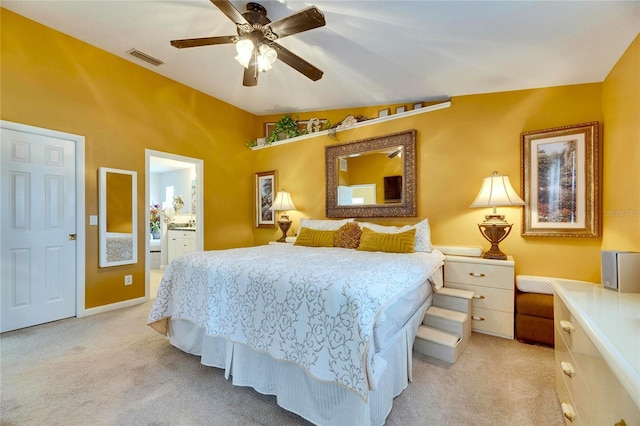 bedroom with light carpet, ceiling fan, lofted ceiling, and connected bathroom