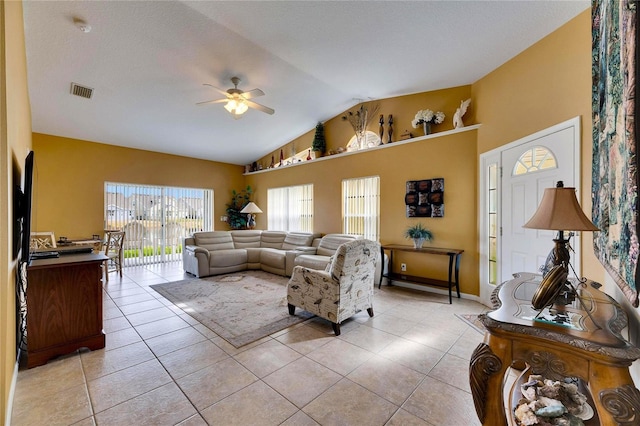 living room featuring ceiling fan, light tile patterned floors, and vaulted ceiling