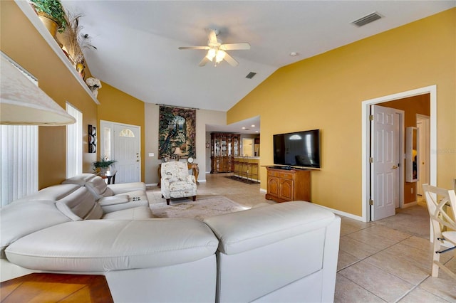 tiled living room with ceiling fan and lofted ceiling