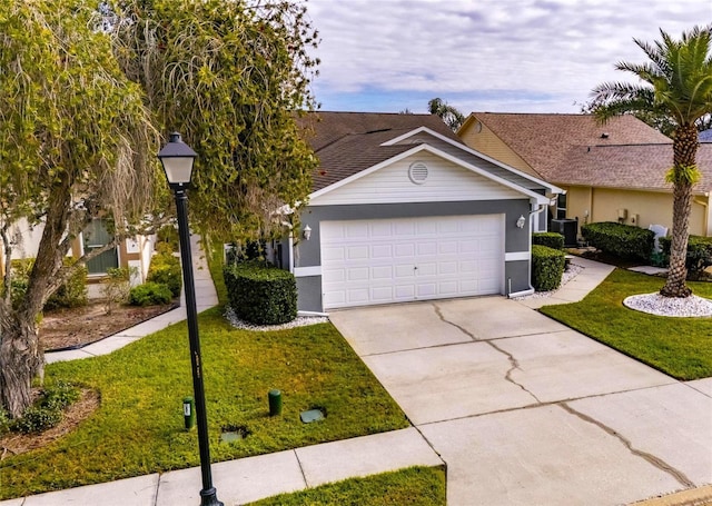 single story home with a front yard, cooling unit, and a garage