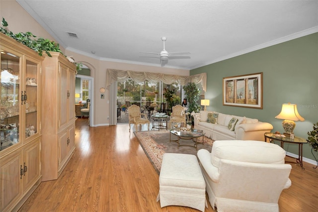 living room featuring ceiling fan, light hardwood / wood-style floors, and ornamental molding