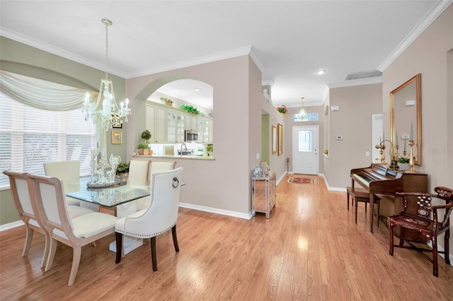 dining area featuring a notable chandelier, crown molding, and light hardwood / wood-style flooring