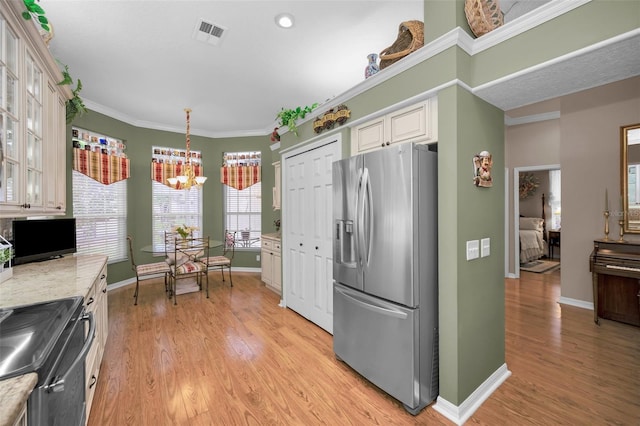 kitchen with stainless steel fridge with ice dispenser, hanging light fixtures, a chandelier, crown molding, and light stone counters