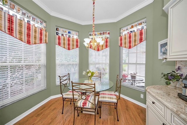 dining space with crown molding, a notable chandelier, and light wood-type flooring