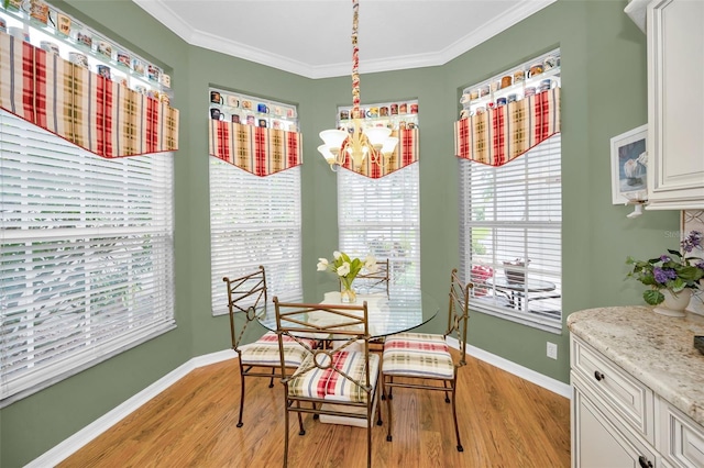 dining space with a chandelier, crown molding, and light hardwood / wood-style flooring