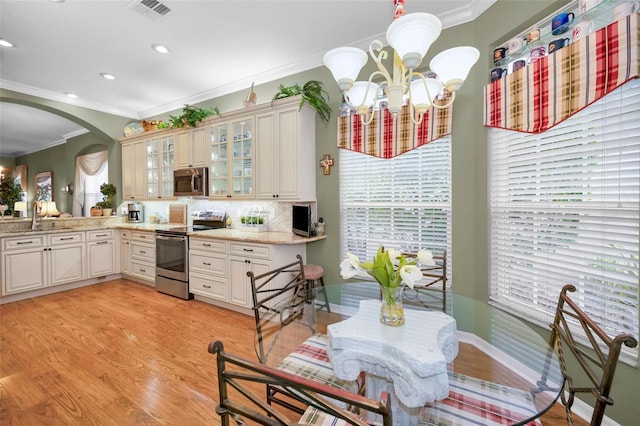 kitchen with tasteful backsplash, appliances with stainless steel finishes, sink, and crown molding