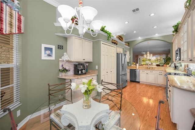 dining room featuring a notable chandelier, ornamental molding, and light hardwood / wood-style floors