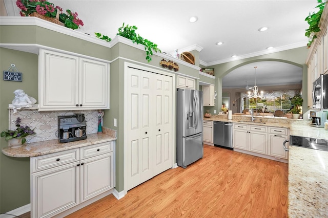 kitchen featuring tasteful backsplash, pendant lighting, crown molding, appliances with stainless steel finishes, and white cabinets