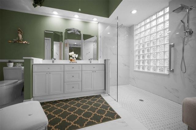 bathroom with toilet, vanity, and tiled shower