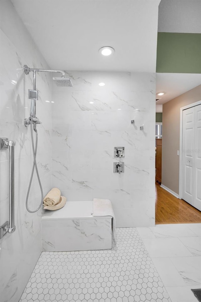 bathroom featuring wood-type flooring and a tile shower