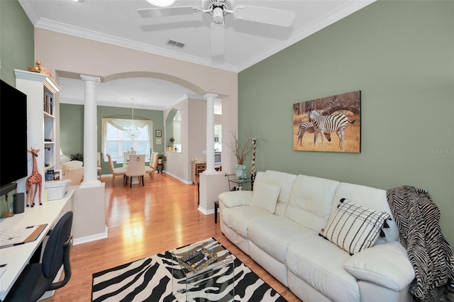 living room featuring ceiling fan, light wood-type flooring, ornamental molding, and decorative columns