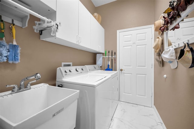 clothes washing area featuring sink, separate washer and dryer, and cabinets