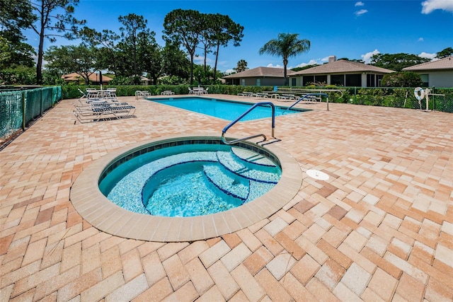 view of swimming pool with a hot tub and a patio area