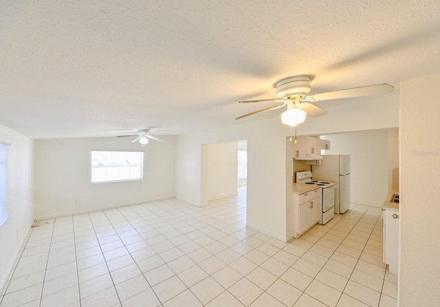 tiled spare room featuring a textured ceiling and ceiling fan