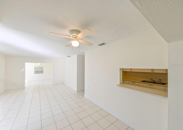 tiled spare room with ceiling fan and sink