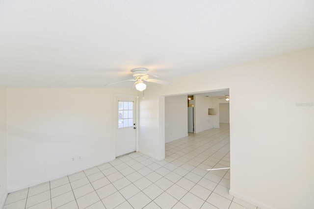 empty room with ceiling fan and light tile patterned floors