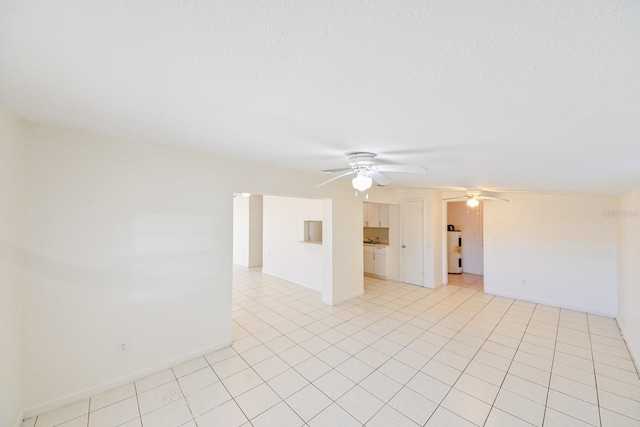 tiled empty room featuring ceiling fan and water heater