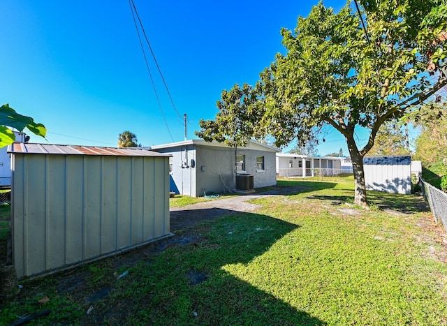 view of yard featuring central AC and a shed