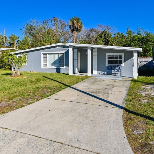 ranch-style home with covered porch and a front yard