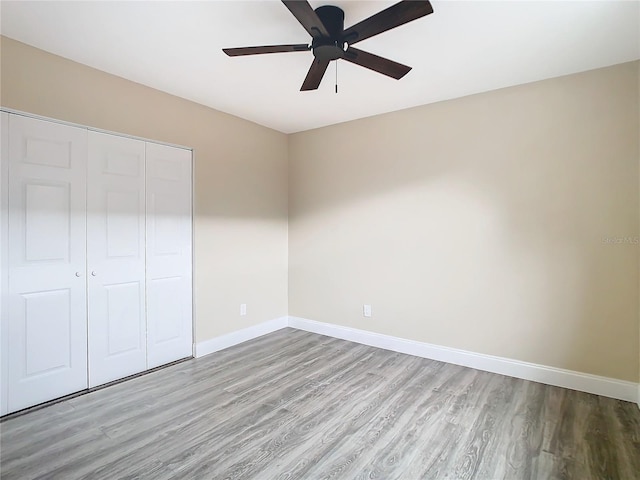 unfurnished bedroom with ceiling fan, a closet, and light hardwood / wood-style flooring