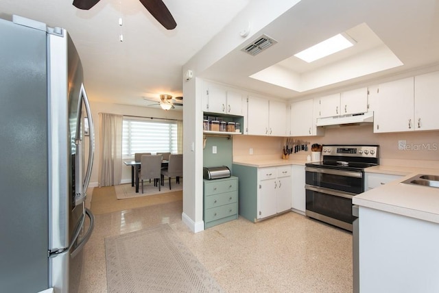 kitchen featuring ceiling fan, white cabinets, appliances with stainless steel finishes, and a raised ceiling