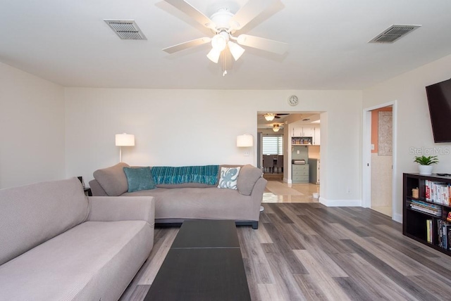 living room featuring ceiling fan and hardwood / wood-style flooring